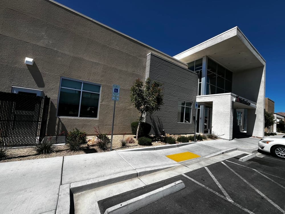 Modern commercial building exterior with large windows and accessible parking space.